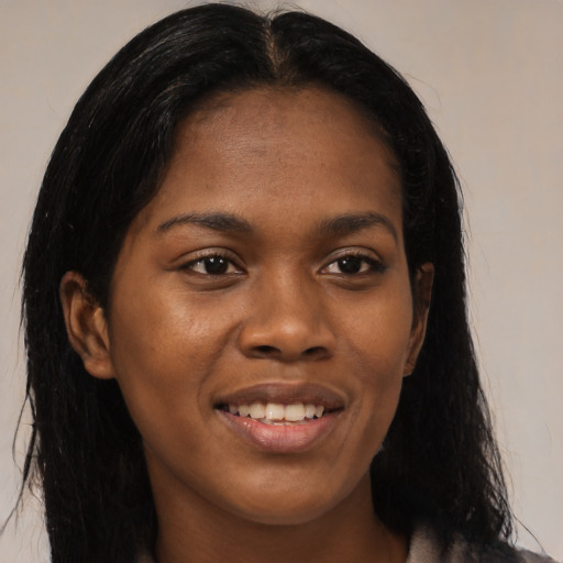 Joyful black young-adult female with medium  black hair and brown eyes