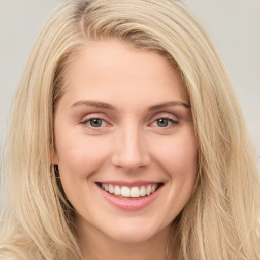 Joyful white young-adult female with long  brown hair and blue eyes