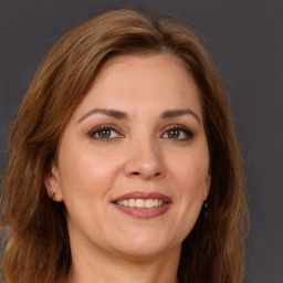 Joyful white adult female with long  brown hair and grey eyes