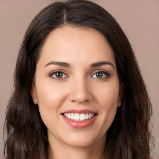 Joyful white young-adult female with long  brown hair and brown eyes