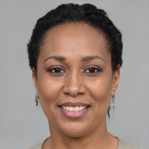 Joyful black adult female with short  black hair and brown eyes