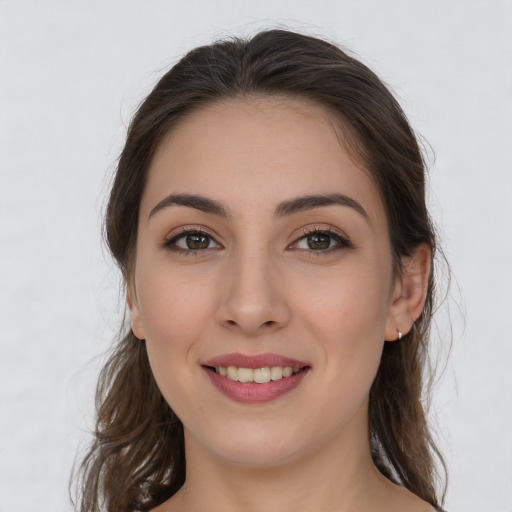 Joyful white young-adult female with long  brown hair and brown eyes