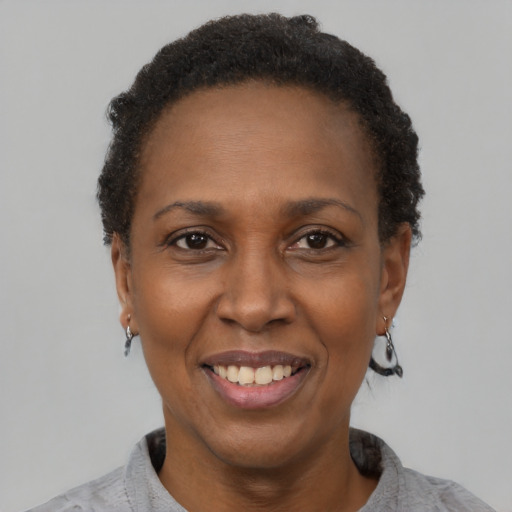 Joyful black adult female with short  black hair and brown eyes