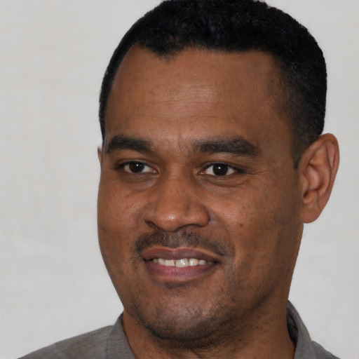 Joyful black young-adult male with short  black hair and brown eyes