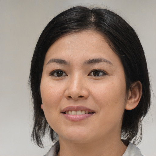 Joyful asian young-adult female with medium  black hair and brown eyes