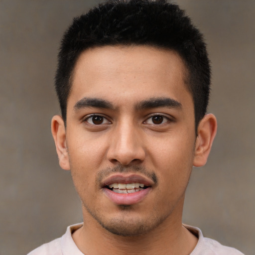 Joyful latino young-adult male with short  black hair and brown eyes