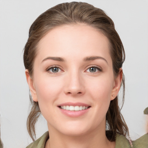 Joyful white young-adult female with medium  brown hair and grey eyes