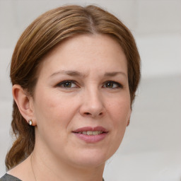 Joyful white adult female with medium  brown hair and grey eyes