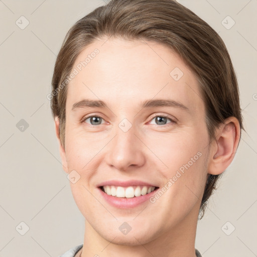 Joyful white young-adult female with medium  brown hair and grey eyes