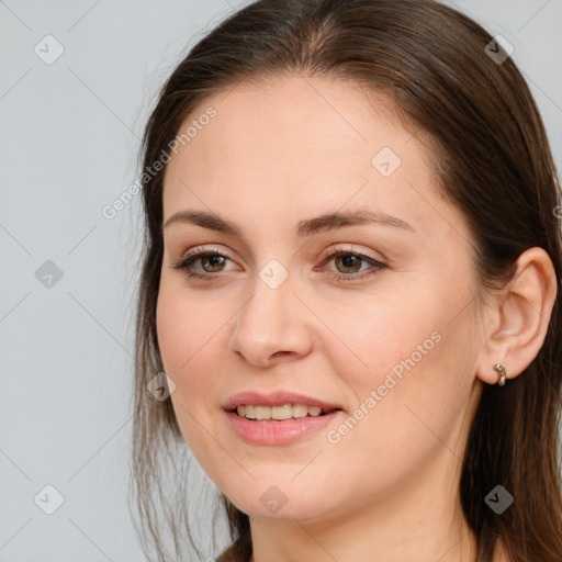 Joyful white young-adult female with long  brown hair and brown eyes