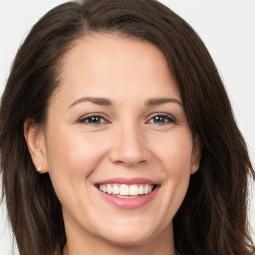 Joyful white young-adult female with long  brown hair and brown eyes