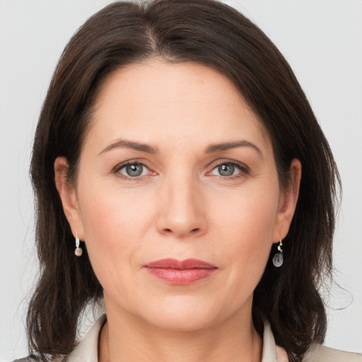 Joyful white adult female with medium  brown hair and grey eyes