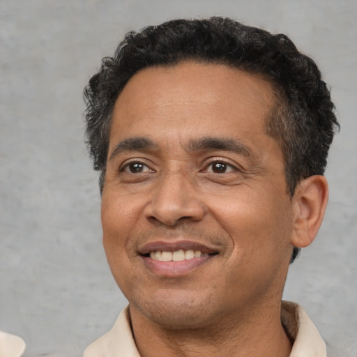 Joyful latino adult male with short  black hair and brown eyes