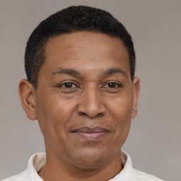 Joyful latino adult male with short  black hair and brown eyes