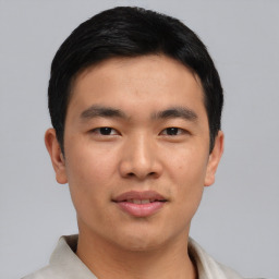 Joyful asian young-adult male with short  black hair and brown eyes