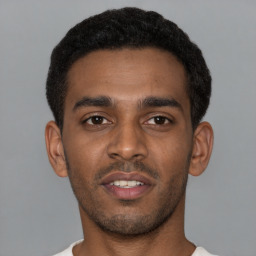 Joyful latino young-adult male with short  brown hair and brown eyes