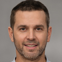 Joyful white adult male with short  brown hair and brown eyes