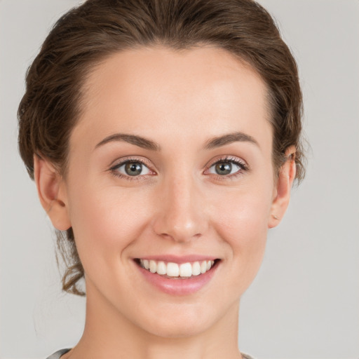 Joyful white young-adult female with short  brown hair and green eyes