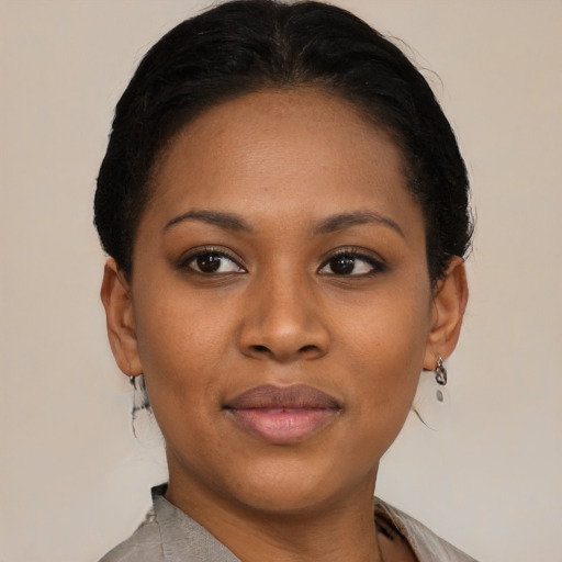 Joyful black young-adult female with short  black hair and brown eyes
