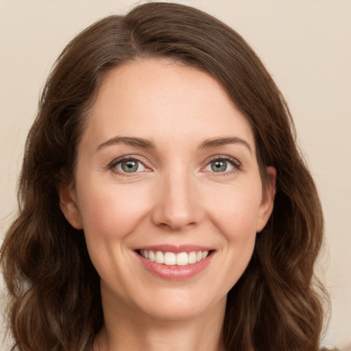 Joyful white young-adult female with long  brown hair and green eyes