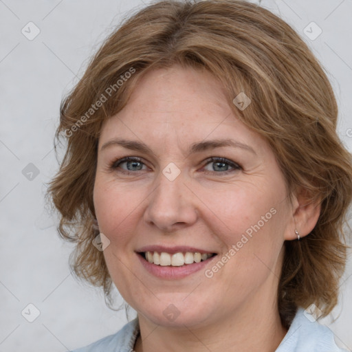 Joyful white adult female with medium  brown hair and blue eyes