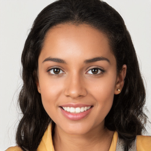 Joyful latino young-adult female with long  brown hair and brown eyes