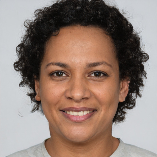 Joyful latino adult female with short  brown hair and brown eyes