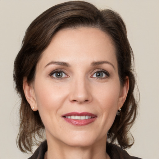 Joyful white adult female with medium  brown hair and grey eyes