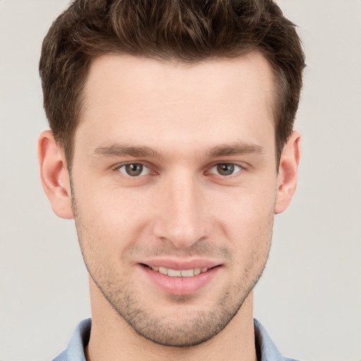 Joyful white young-adult male with short  brown hair and grey eyes