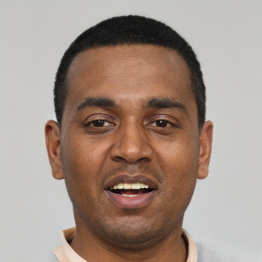 Joyful black young-adult male with short  black hair and brown eyes