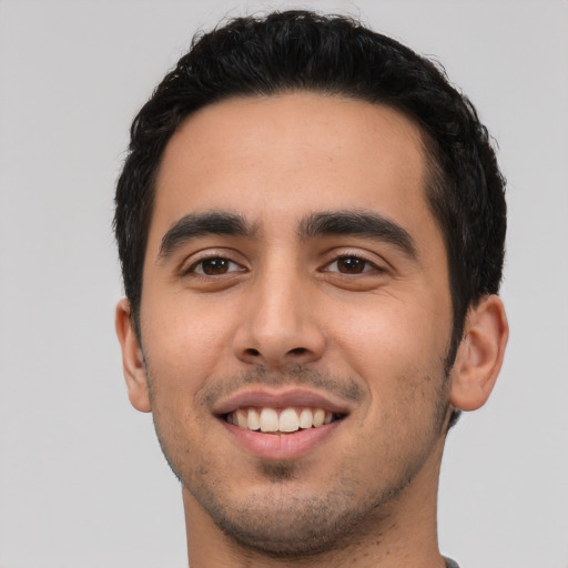 Joyful latino young-adult male with short  black hair and brown eyes