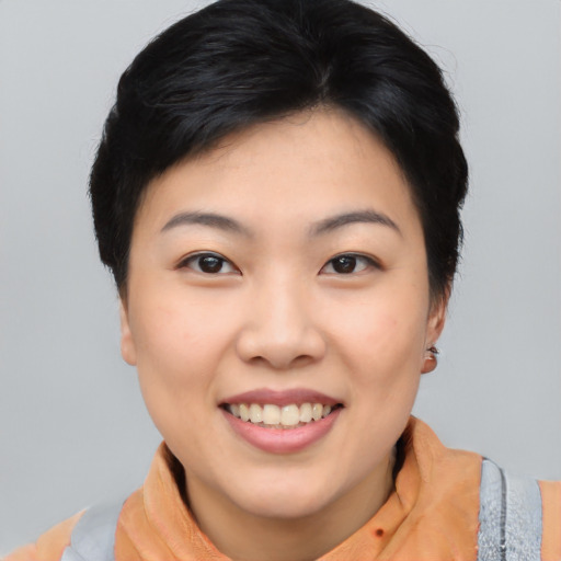 Joyful asian young-adult female with short  black hair and brown eyes
