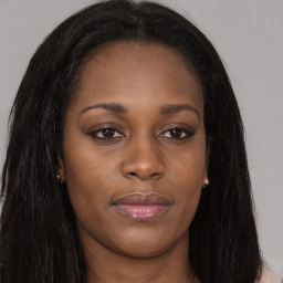 Joyful black young-adult female with long  brown hair and brown eyes