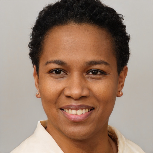 Joyful black young-adult female with short  black hair and brown eyes
