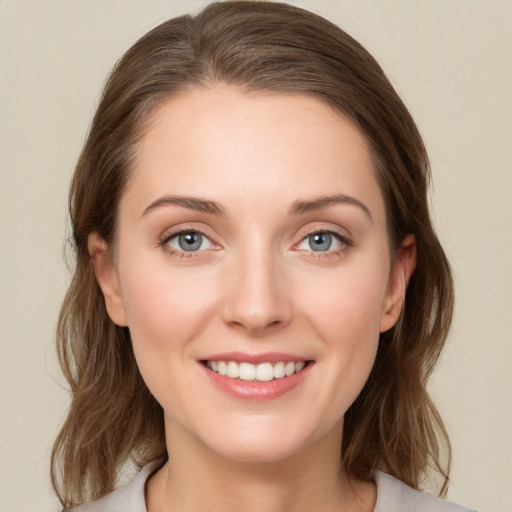 Joyful white young-adult female with medium  brown hair and green eyes