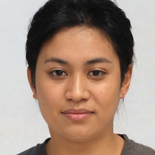 Joyful latino young-adult female with short  black hair and brown eyes