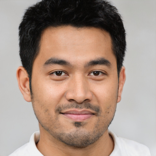 Joyful latino young-adult male with short  black hair and brown eyes