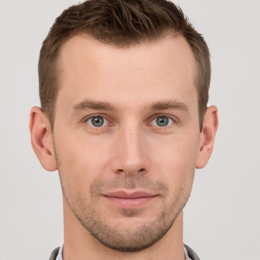 Joyful white young-adult male with short  brown hair and grey eyes