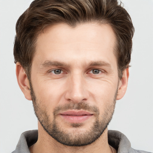 Joyful white young-adult male with short  brown hair and grey eyes