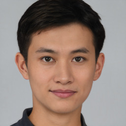 Joyful asian young-adult male with short  brown hair and brown eyes