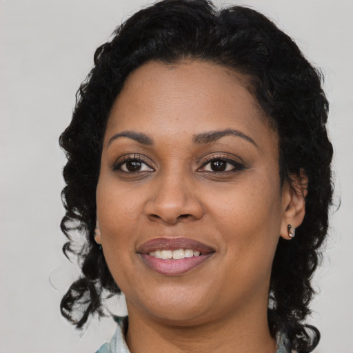 Joyful black young-adult female with long  brown hair and brown eyes
