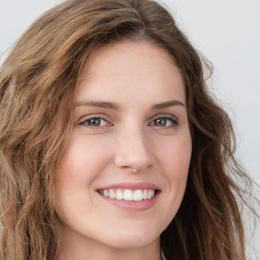 Joyful white young-adult female with long  brown hair and green eyes