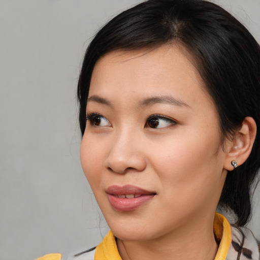 Joyful asian young-adult female with medium  brown hair and brown eyes
