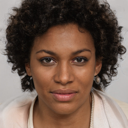 Joyful black young-adult female with medium  brown hair and brown eyes