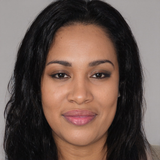 Joyful black young-adult female with long  black hair and brown eyes