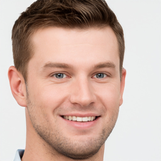 Joyful white young-adult male with short  brown hair and grey eyes