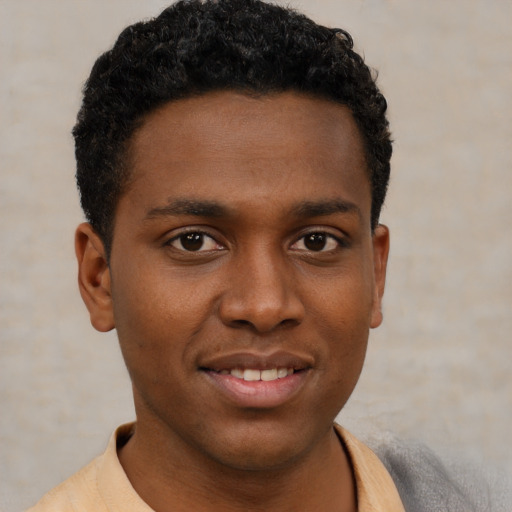 Joyful black young-adult male with short  brown hair and brown eyes