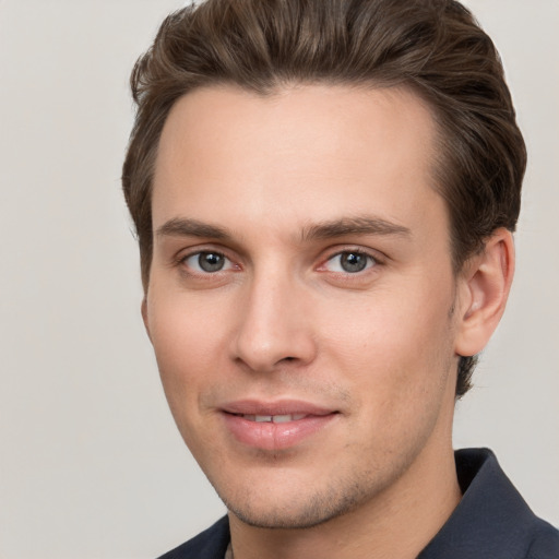 Joyful white young-adult male with short  brown hair and grey eyes