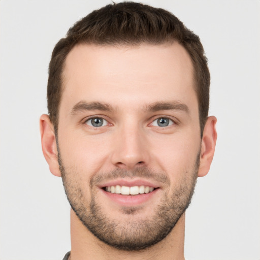 Joyful white young-adult male with short  brown hair and grey eyes