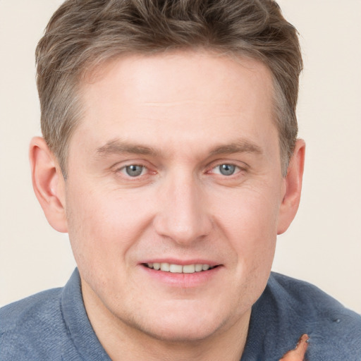 Joyful white young-adult male with short  brown hair and blue eyes